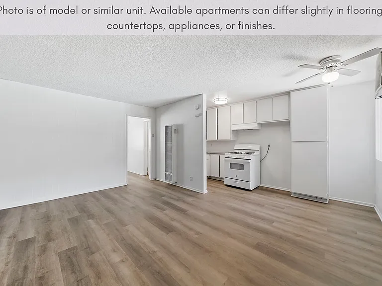 Spacious open-concept living area with modern flooring and an efficient kitchen design.