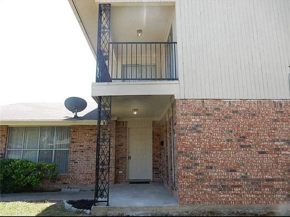 Front door of home with balcony upstairs.