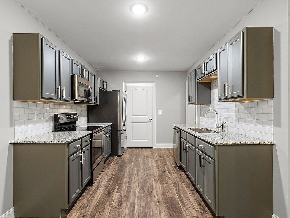 Sleek modern kitchen featuring elegant grey cabinetry, stainless steel appliances, and stylish wood flooring.