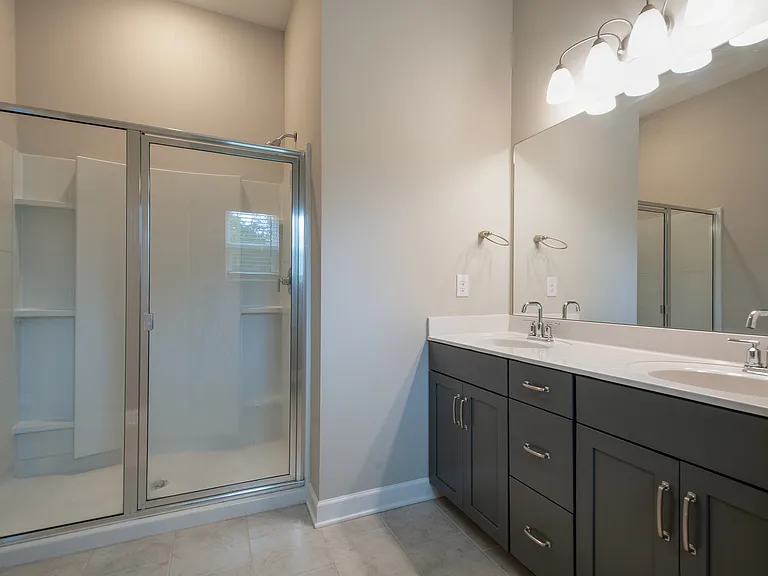 Primary bath with a double vanity and a large shower.