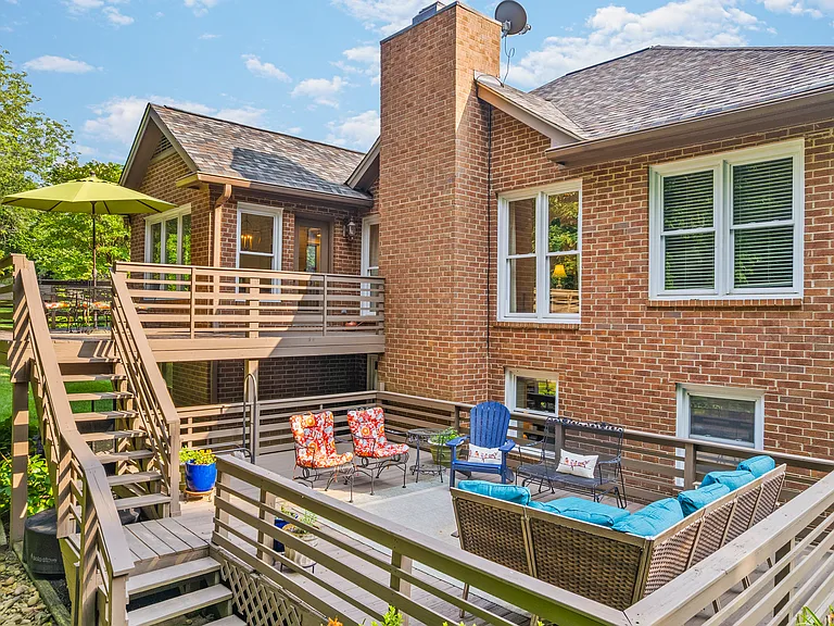 Spacious lower patio with plenty of outdoor seating and beautiful views of the private, wooded backyard.