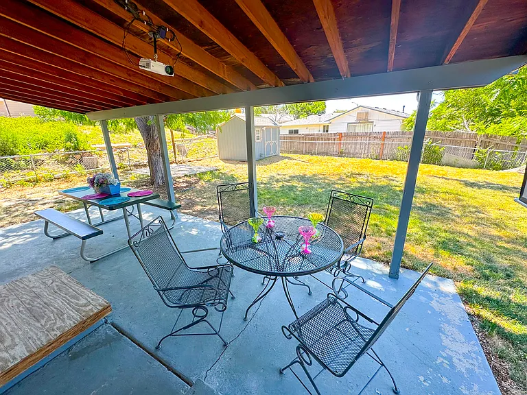 Your private backyard escape with cozy seating, a dining table, and a projector for ultimate relaxation!