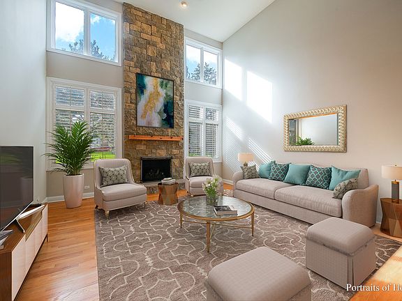 Family room with plantation shutters and 2-story stone fireplace