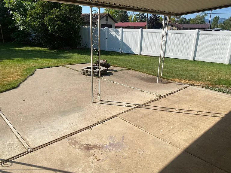 Huge backyard with fire pit, clothesline, garden boxes, shed, covered patio, mature trees, and plenty of room to play/relax.