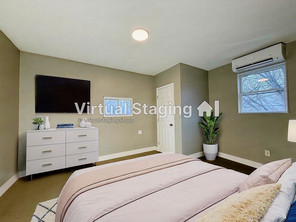 This virtually staged bedroom features a sleek design, modern lighting & a wall-mounted TV setup.