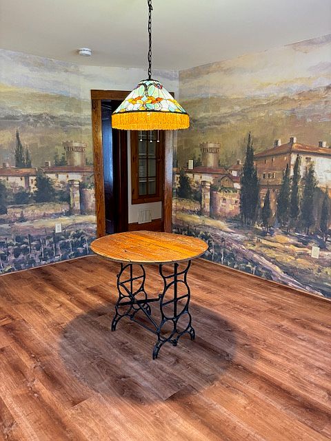 Another angle of dining room with all new luxury vinyl plank floors and mural with scene of landscape of the hills of Italy.