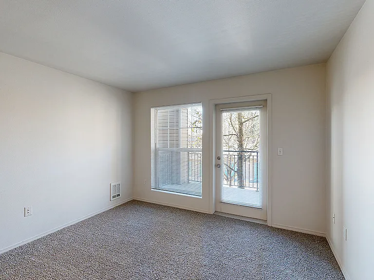 Apartment living room with plush carpet flooring.
