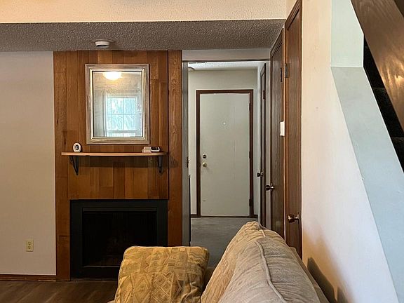 Living room with fireplace and doorway into the kitchen. Upstairs on the right.