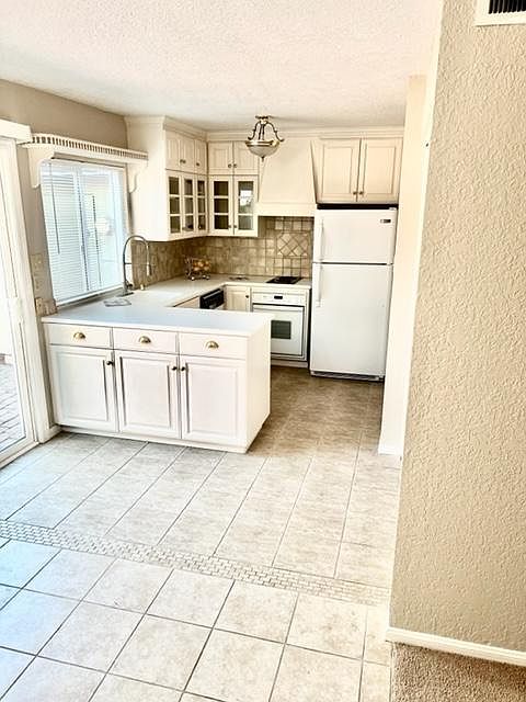 Custom kitchen with tile back splash and Corian countertop