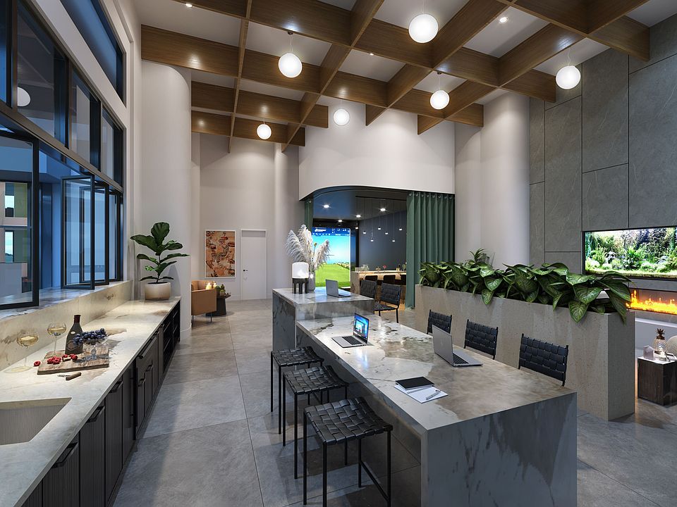 The expansive clubroom features lounge seating and a golf simulator, offering a versatile space for recreation and socializing.