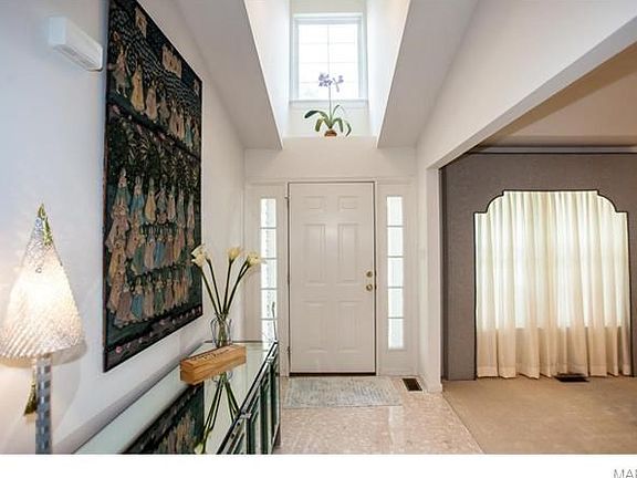Vaulted entry foyer with marble flooring and dormer window