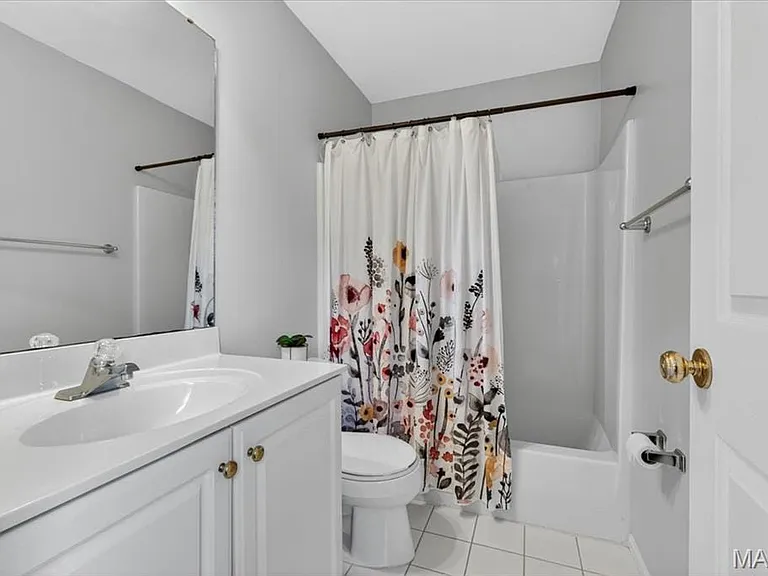 Bathroom featuring a white vanity with integrated sink, chrome faucet, and gold-toned hardware