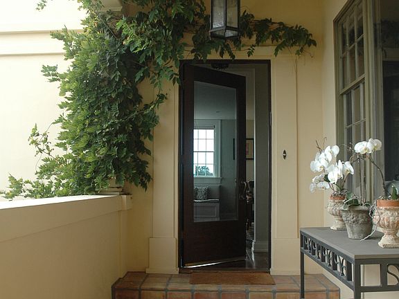Front entry way draped in Wisteria and custom iron lighting