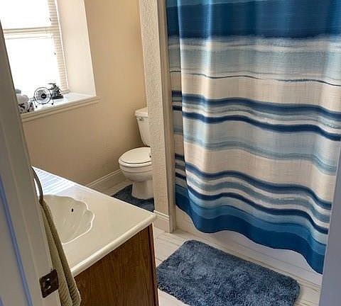 Bathroom featuring tile patterned flooring, toilet, and vanity