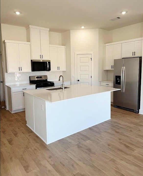 Open kitchen/bar with fridge, gas stove, microwave, dishwasher.