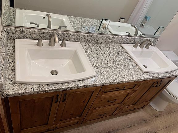 Kohler double sinks in Master bathroom with granite counters and custom cabinetry.
