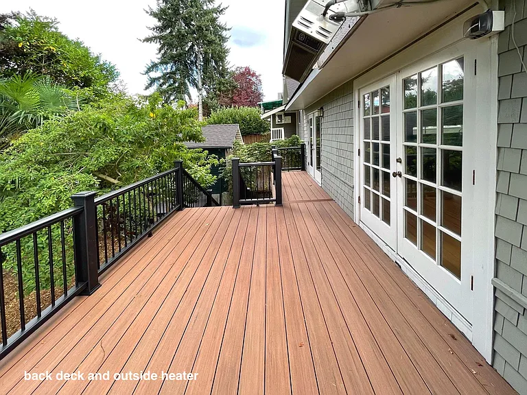 outdoor deck with outdoor gas heater (photo facing north) overlooking secluded back yard