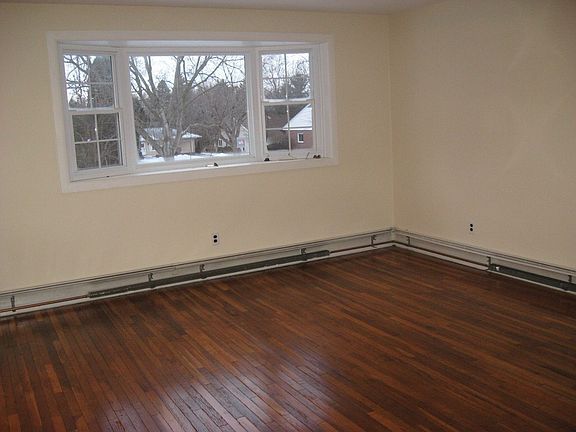 Living room with bow window and newly refinished hardwood floors.