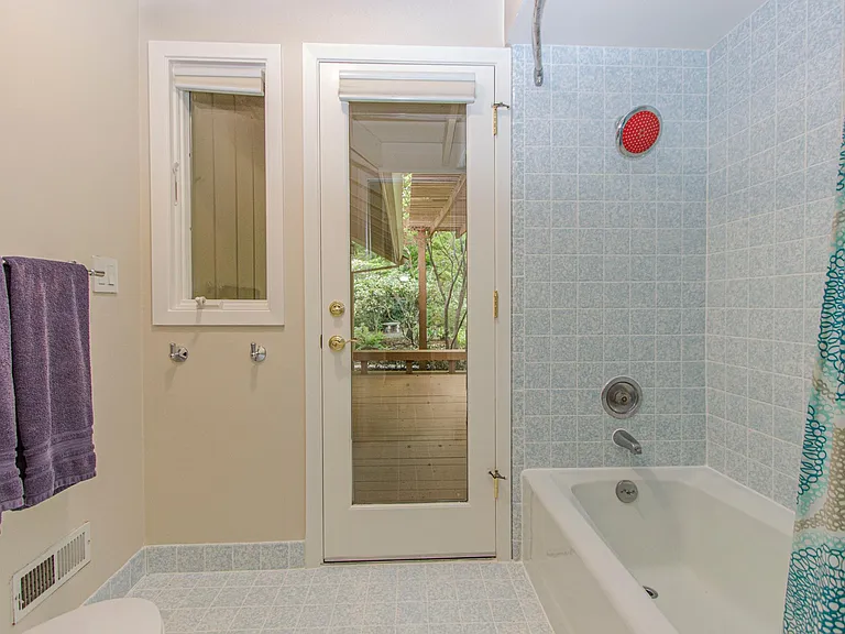 Split bathroom with tub/shower and access to backyard