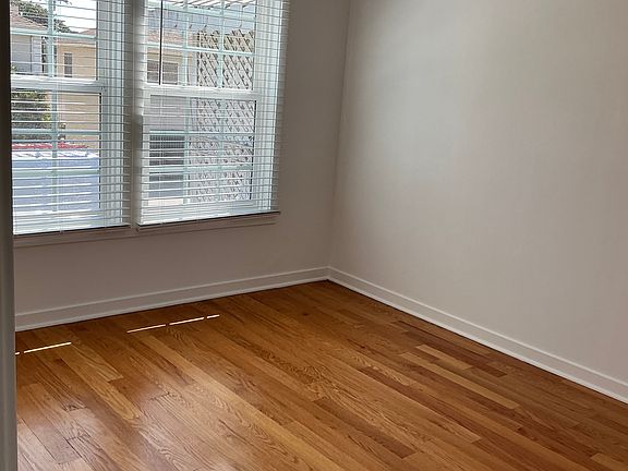 Bedroom with real hardwood floors and lots of natural light.