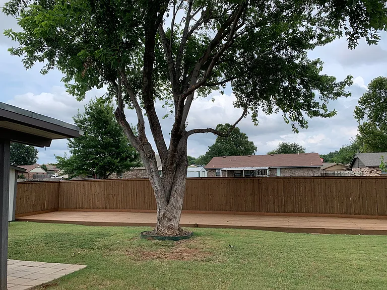 Large wooden deck across the back of yard for entertaining