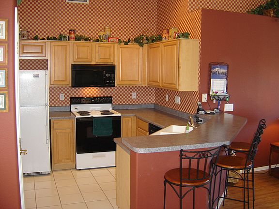 A open upgraded kitchen with raised panel honey maple cabinetry.