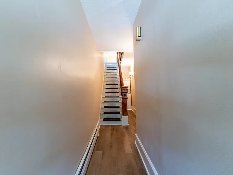 Entrance hallway from front door up stairs into the main floor of the apartment. The laundry is located on the side of the stairs.