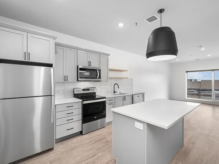Contemporary kitchen featuring sleek gray cabinetry, stainless steel appliances, and a spacious island under modern lighting. Contemporary kitchen featuring sleek gray cabinetry, stainless steel appliances, and a spacious island under modern lighting.