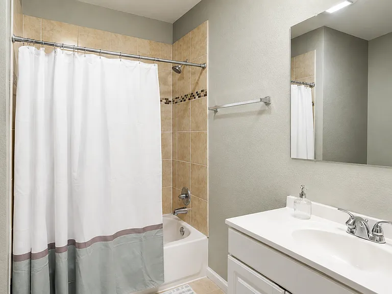 Dedicated Private Bathroom _ Reserved exclusively for the Garden Suite, this full bathroom features a modern vanity, bright lighting, and a bathtub with shower, providing added privacy and everyday convenience.