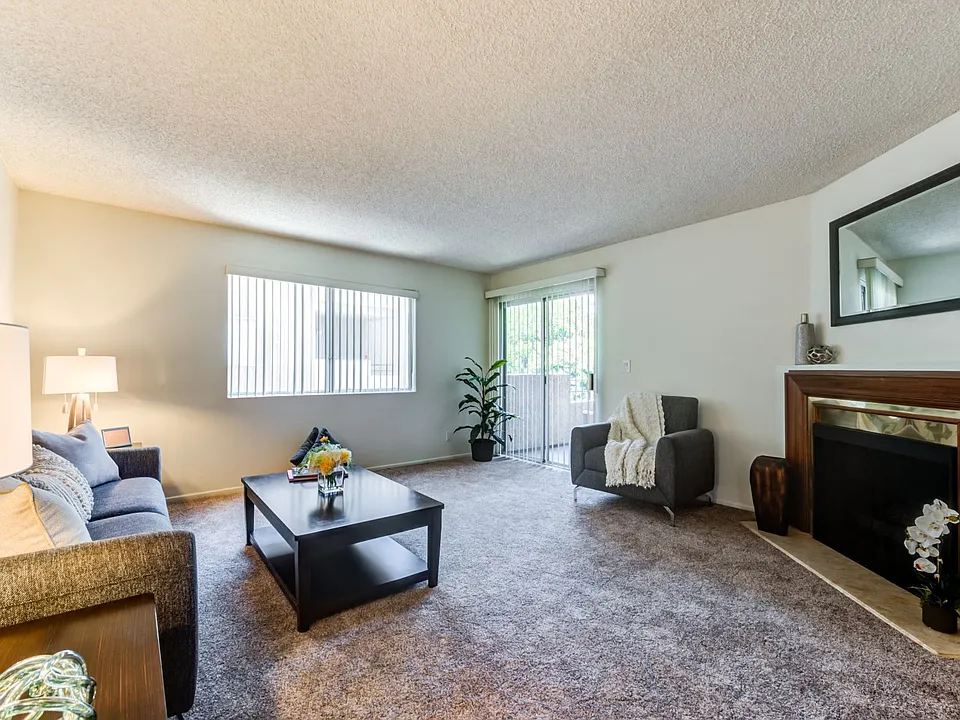 Spacious living room with fireplace at the Plaza Apartments in Sherman Village