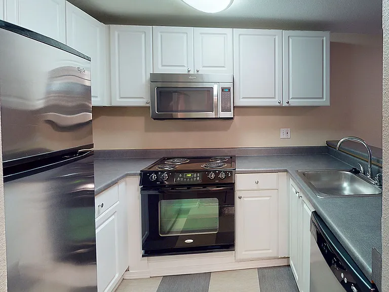 Apartment kitchen with tile flooring.