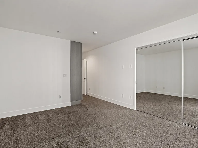 Bedroom with Mirrored Closet and Additional Cabinet Storage