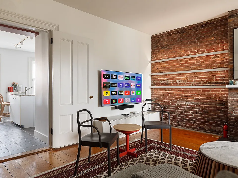 View from living room into kitchen - wall mounted 65" OLED TV with Sonos Sound Bar.