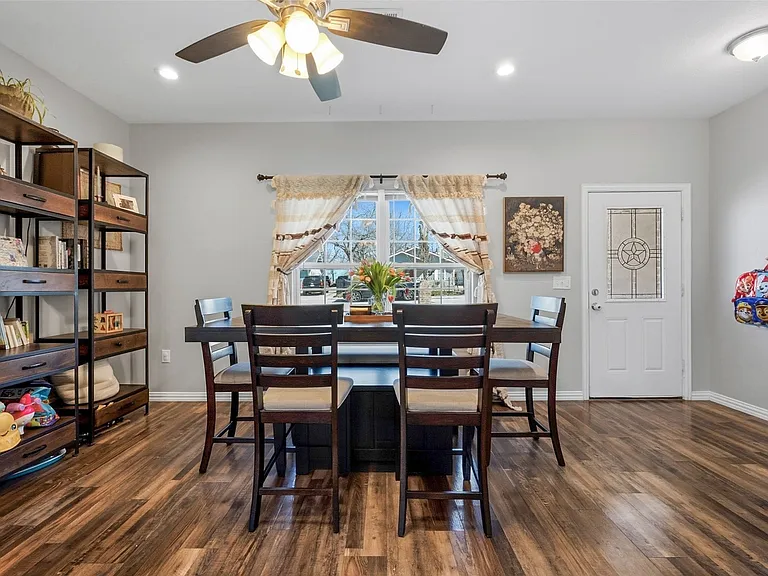 Bright interior space featuring wood-finish flooring, light gray walls, and a multi-pane window with exterior views