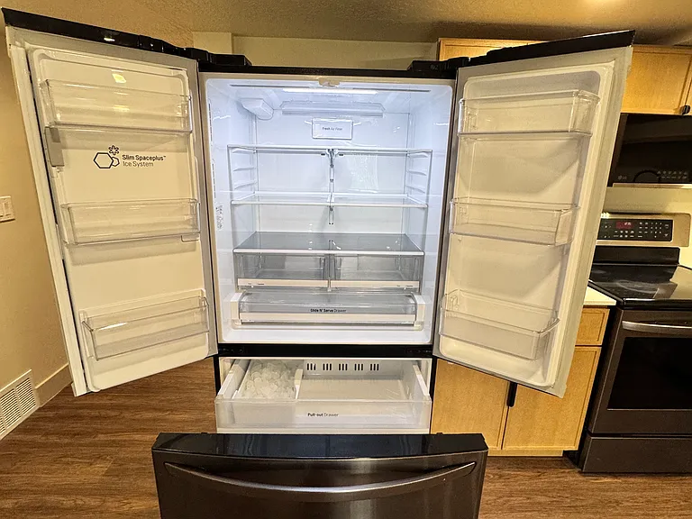 Modern kitchen featuring stainless steel French-door refrigerator, sleek cabinetry, and clean finishes.