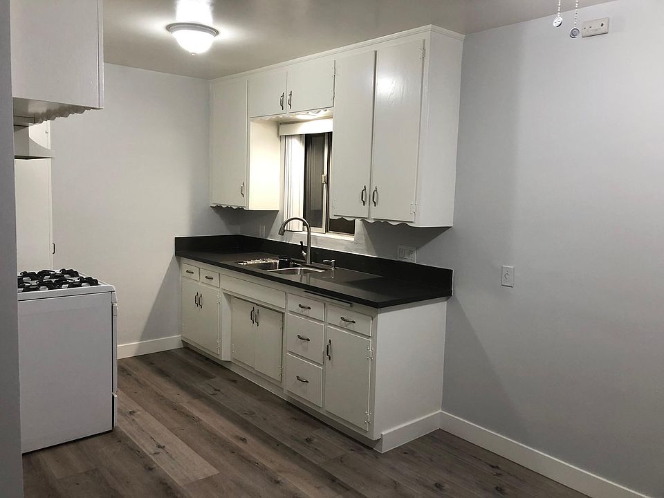 New kitchen counter, sink & faucet. Light grey walls, new flooring & baseboards.