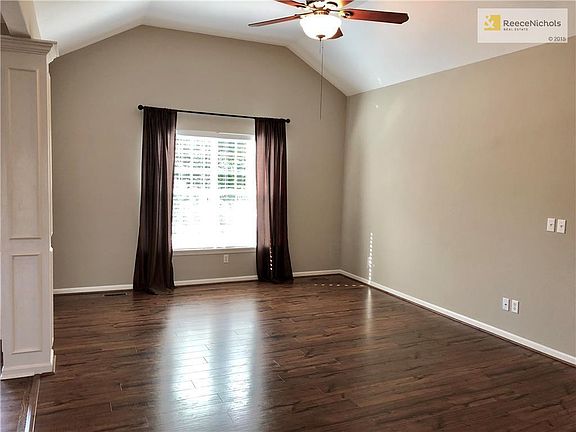 Vaulted Great Room w/Ceiling Fan, Laminate Flooring & Corner Fireplace.