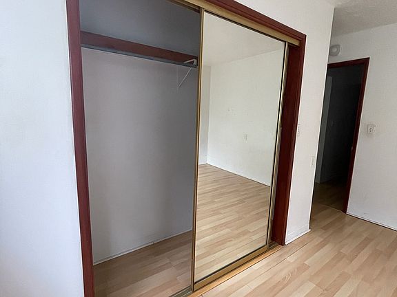 Bedroom on right side with large mirror closet doors.