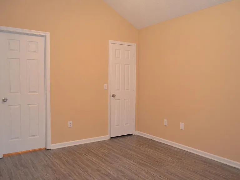 View looking towards master bath door and walk-in closet door on the right
