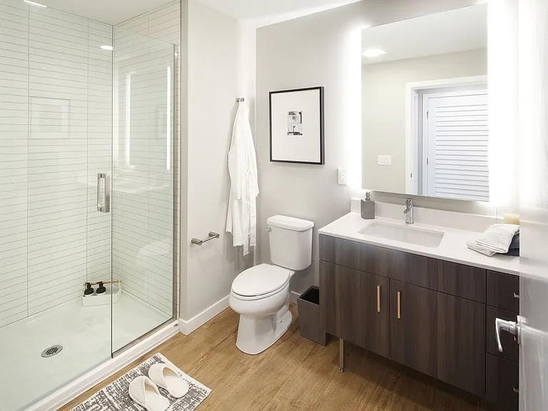 Scheme II bath with dark cabinetry, white quartz countertop, and hard surface flooring.