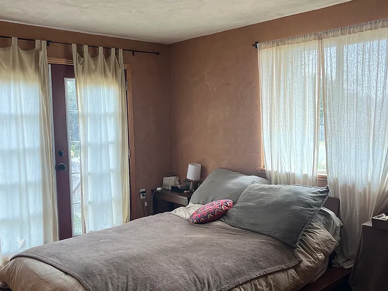 This is the largest of the two original bedrooms. It has American Clay on the walls, wooden closet doors on a large closet, and French doors to the south side of the property.