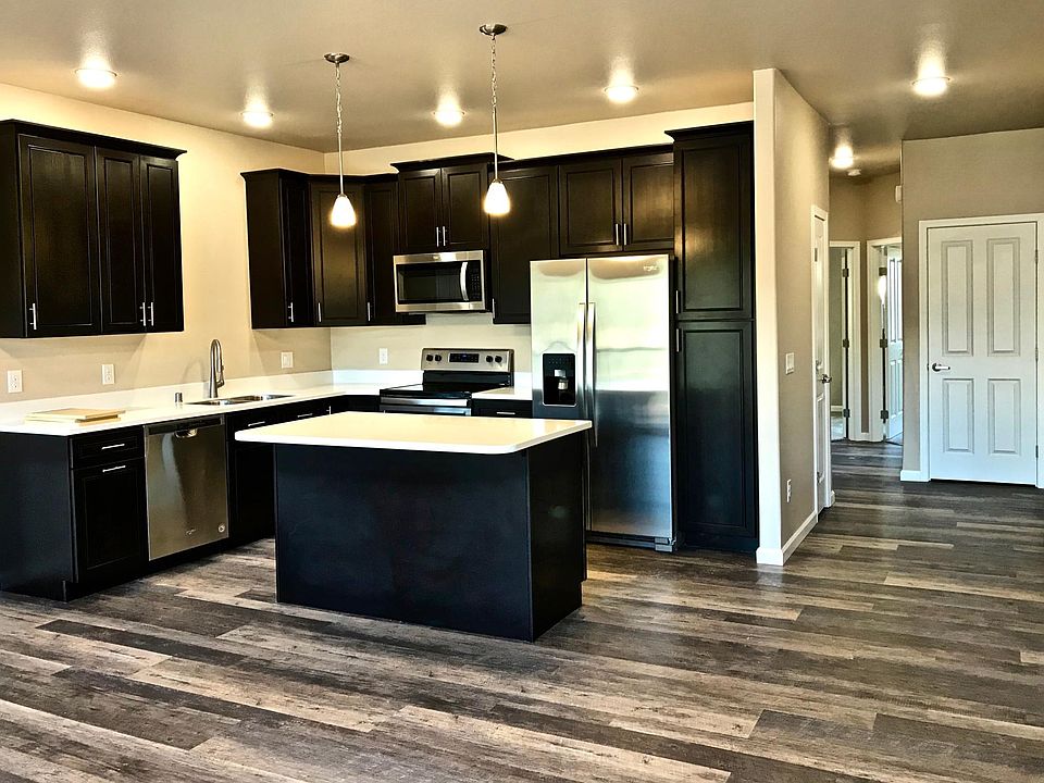 Kitchen with island in great room, hall closets, doors to bedrooms. Entry door to right by closet door.