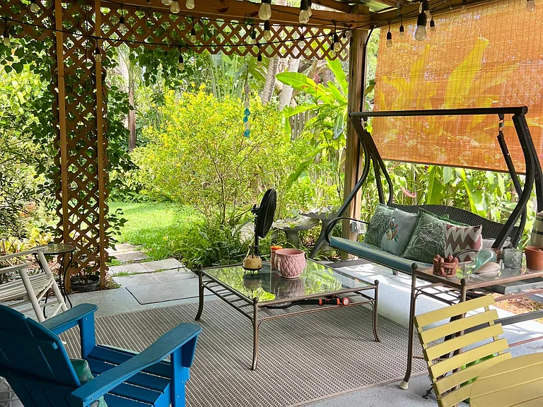 Outdoor covered patio with ceiling fan and lighting.