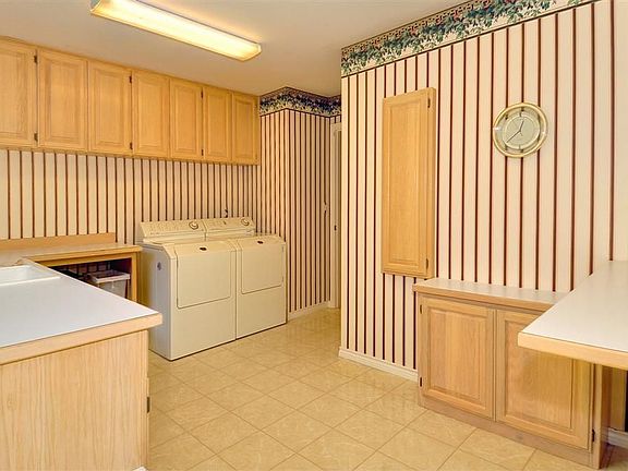 One of the largest and best laundry rooms ever! Utility sink, tons of cabinets, built-in ironing boa