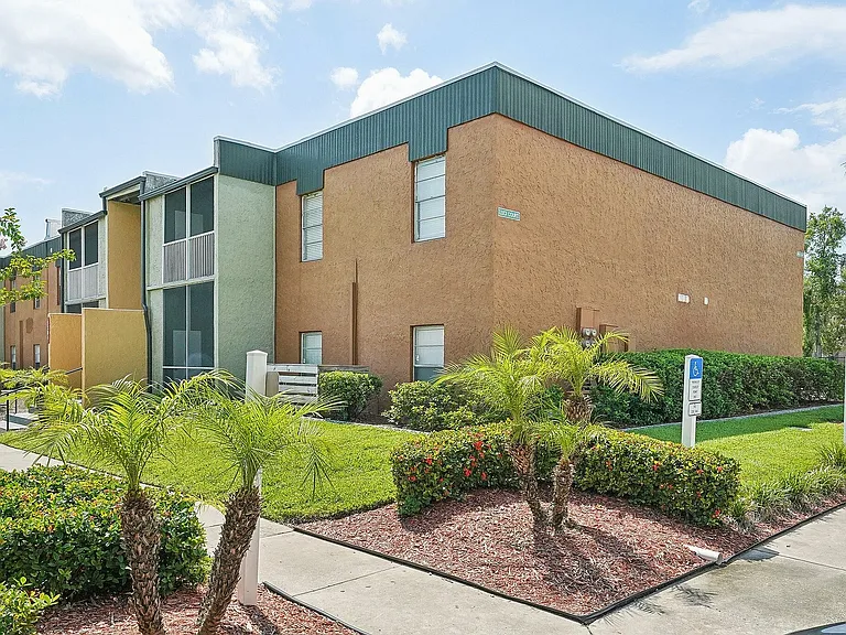 Beautifully maintained residential building with modern design, surrounded by lush greenery and vibrant landscaping.