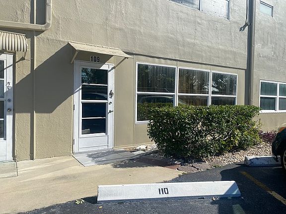 Rear door entry located a few steps away from carport included with rental.