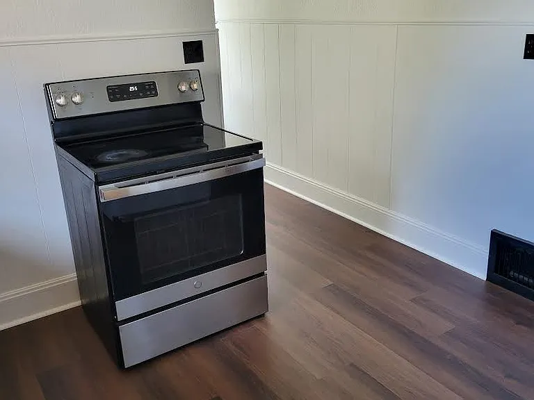 Kitchen with stove and new windows.