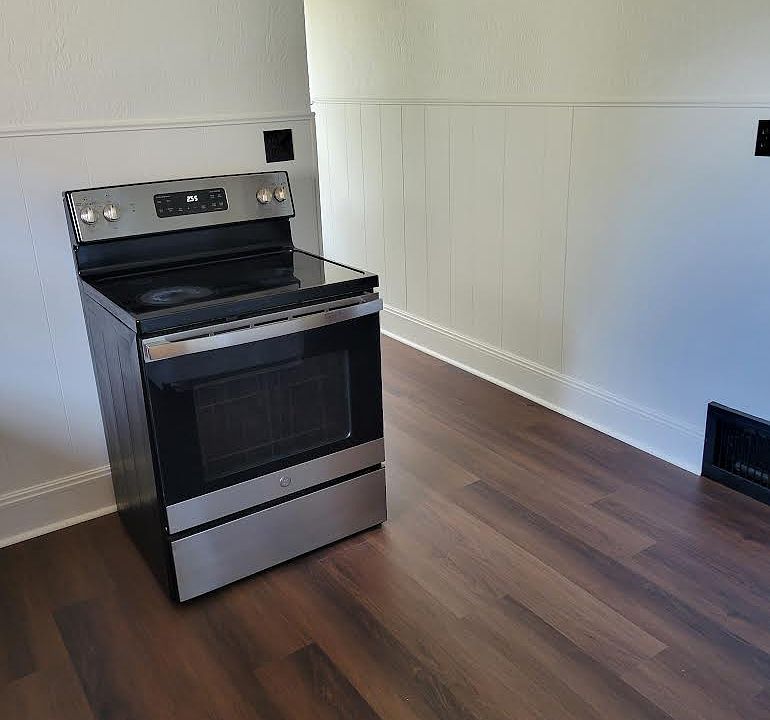 Kitchen with stove and new windows.