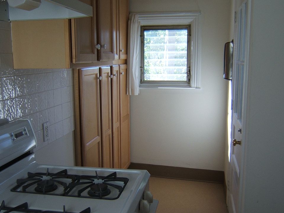 gas stove and wall of cabinets across is door to outside fire escape - leads to space big enough for small grill and chairs