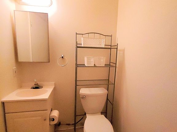 1/2 bath adjacent to the kitchen. The washer and dryer are across from the vanity.